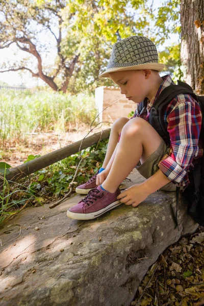 男孩在森林里系鞋带 — 图库照片