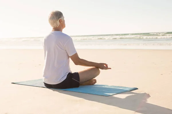 Starszy człowiek robi joga na plaży — Zdjęcie stockowe