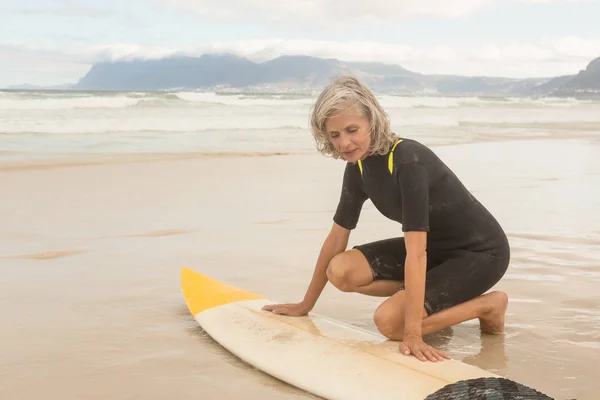 Старша жінка готується до серфінгу — стокове фото