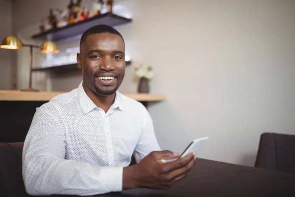 Hombre usando teléfono móvil en restaurante — Foto de Stock