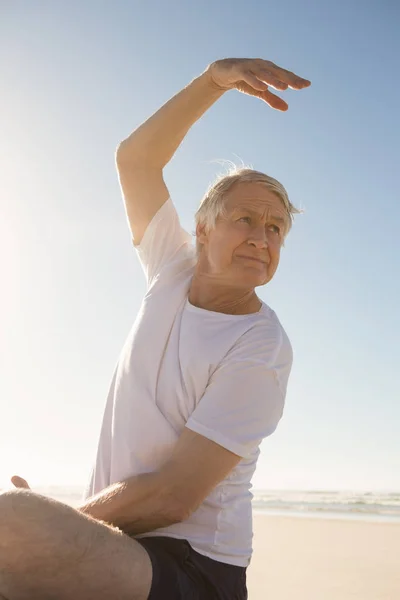 Uomo anziano che fa yoga sulla spiaggia — Foto Stock