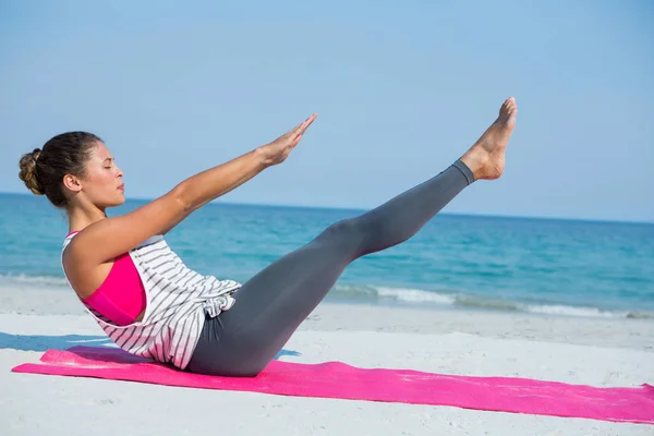 Woman with eyes closed exercising on mat — Stock Photo, Image