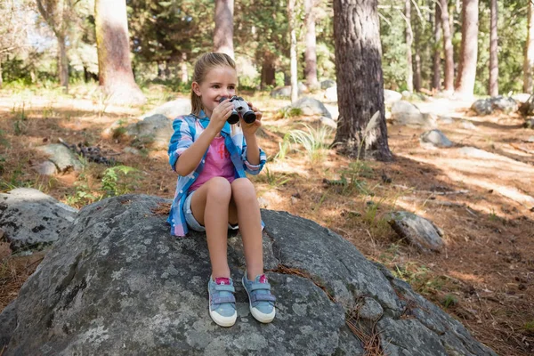 Dívka při pohledu dalekohledem v lese — Stock fotografie