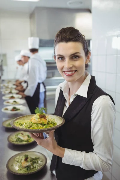 Serveuse montrant la vaisselle à la caméra — Photo