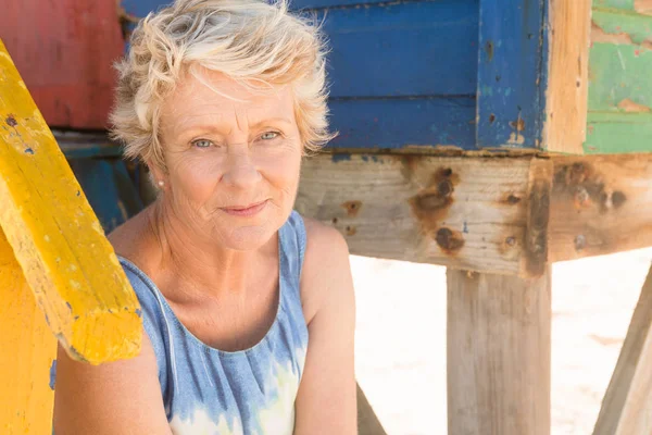 Mujer mayor sentada en los escalones de la cabaña de playa —  Fotos de Stock