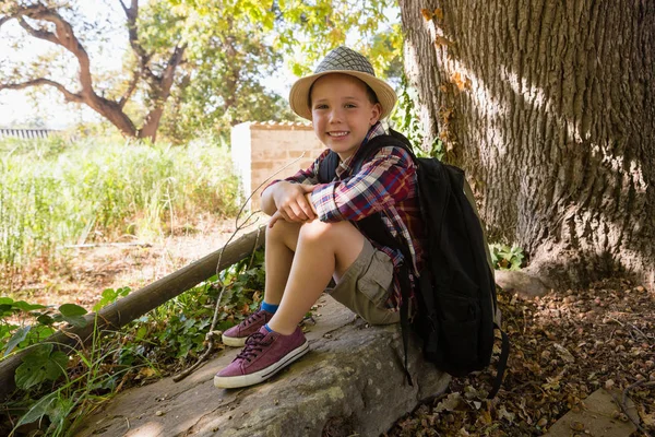 Usměvavý chlapec sedí v lese — Stock fotografie