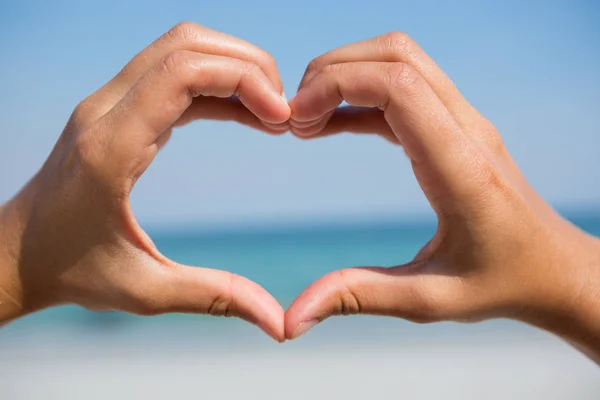 Handen waardoor hart vorm op strand — Stockfoto