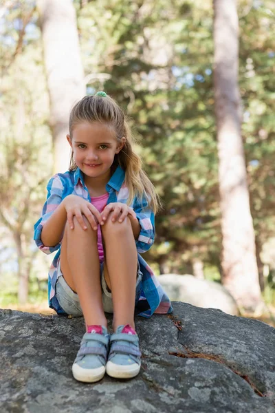 Smiling girl sitting on the rock — Stock Photo, Image