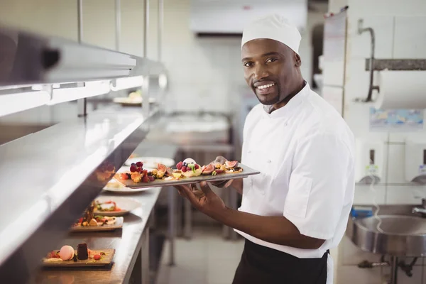 Шеф-кухар тримає десертний лоток на кухні — стокове фото