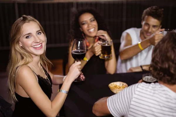 ナイトクラブで友達とワイングラスを持つ女性 — ストック写真