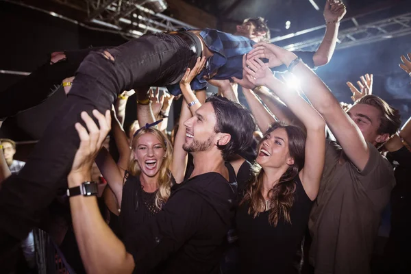 Fans joyeux soulevant interprète masculin — Photo