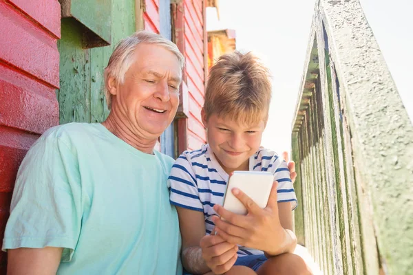 Хлопчик з дідом за допомогою смартфона — стокове фото