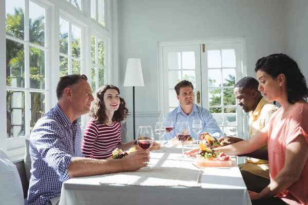 Friends interacting while having meal — Stock Photo, Image