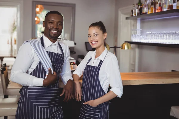 Waiter and waitress standing at counter — Stock Photo, Image