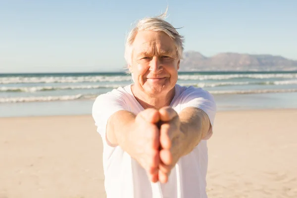 Uomo anziano che fa yoga sulla spiaggia — Foto Stock