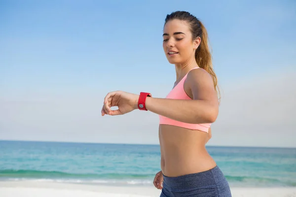 Жінка дивиться на розумний годинник під час бігу — стокове фото