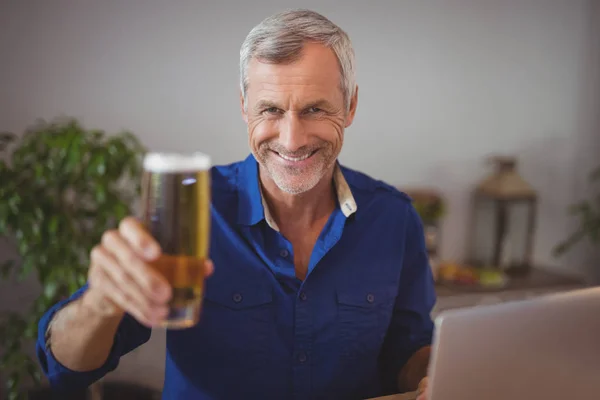 Homme mature tenant verre de bière — Photo