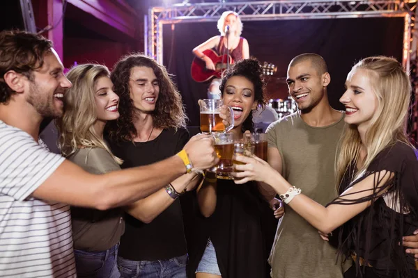 Lachende vrienden het roosteren van bierglazen — Stockfoto