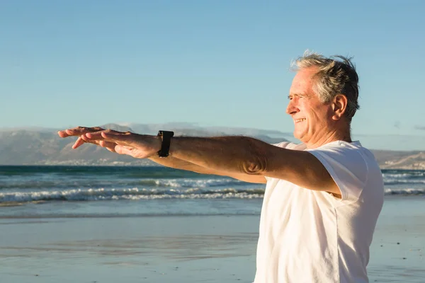 Uomo anziano che esercita in spiaggia — Foto Stock