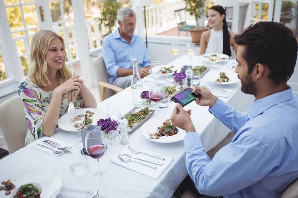 Mann fotografiert Lebensmittel vom Handy — Stockfoto