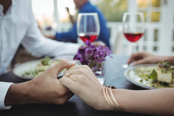 Pasangan berpegangan tangan sambil makan — Stok Foto