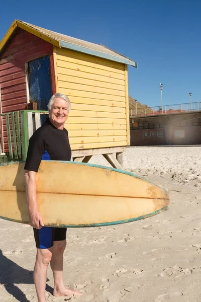 Senior man carrying surfboard — Stock Photo, Image