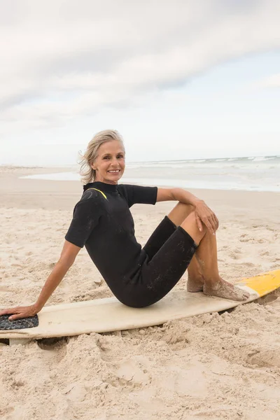 Donna con tavola da surf in spiaggia — Foto Stock