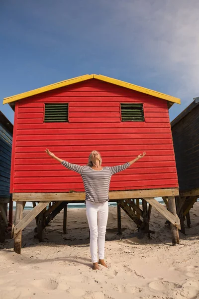 Mulher de pé na areia contra cabana — Fotografia de Stock