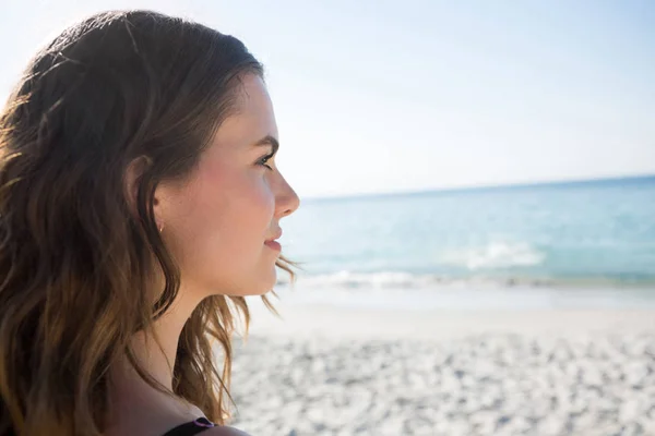 Задумчивая женщина смотрит в сторону пляжа — стоковое фото