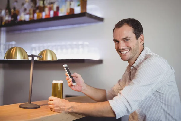 Człowiek za pomocą telefon mając beer — Zdjęcie stockowe