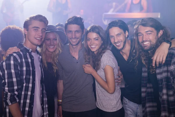 Friends with arm around in nightclub — Stock Photo, Image