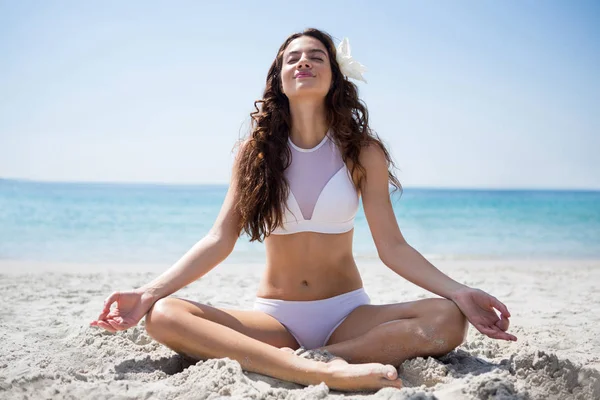 Mulher meditando enquanto sentado na areia — Fotografia de Stock