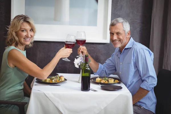 Couple griller leurs verres de vin rouge — Photo