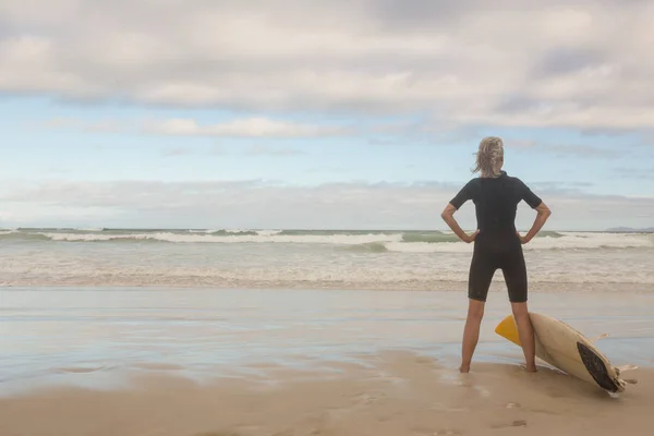 Vrouw met surfboard op strand — Stockfoto