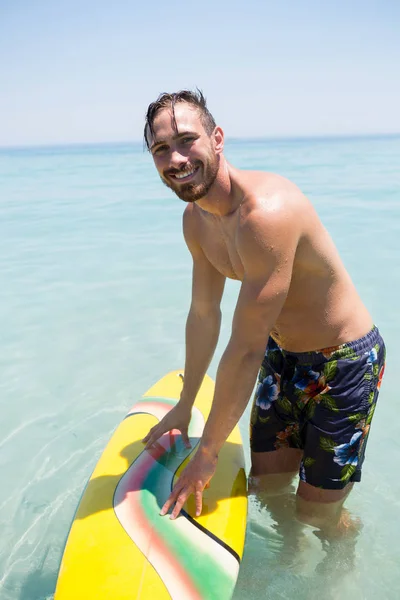 Hombre sin camisa con tabla de surf en el mar — Foto de Stock