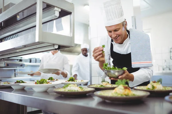 Chef garnishing appetizer plates at order station — Stock Photo, Image