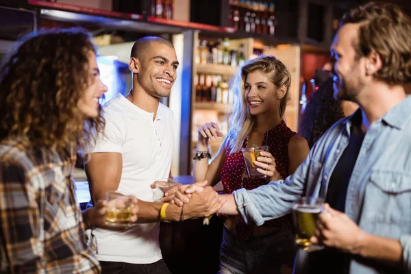 Male friends doing handshake at counter — Stock Photo, Image