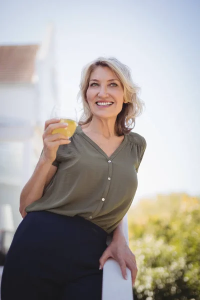 Mogen kvinna som håller ett glas saft — Stockfoto