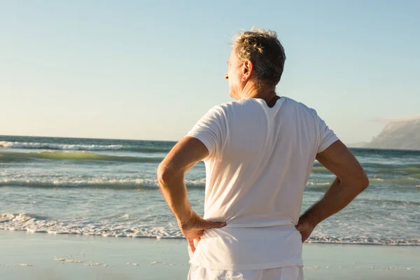 Człowiek z ręki na hip stojący na brzegu — Zdjęcie stockowe
