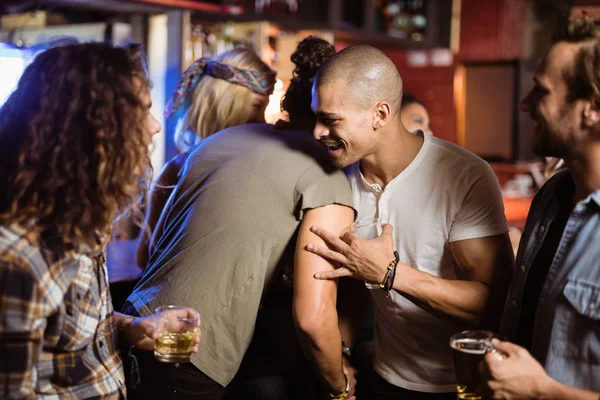 Amigos sonrientes abrazándose en el club nocturno —  Fotos de Stock