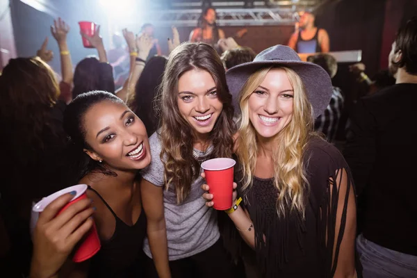 Female friends with disposable cups in club — Stock Photo, Image