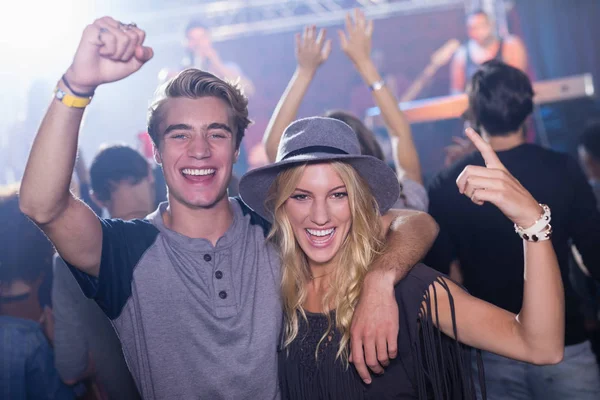 Glada vänner med arm runt på nattklubb — Stockfoto