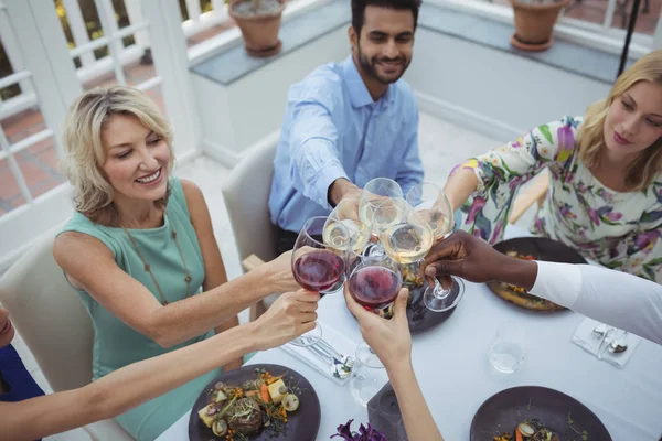 Przyjaciele opiekania kieliszki do wina w restauracji — Zdjęcie stockowe