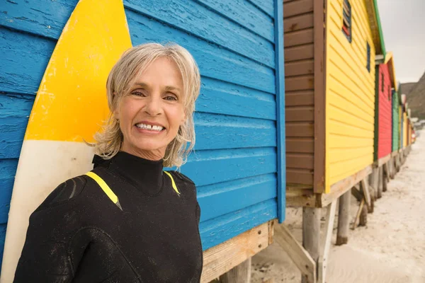 Mujer de pie con tabla de surf — Foto de Stock