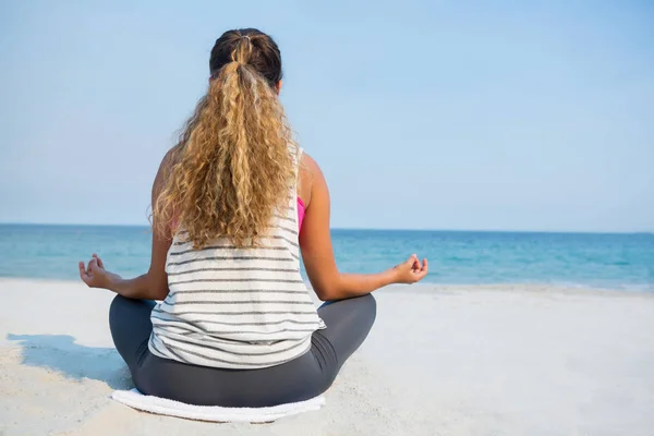 Frau meditiert am Strand im Sand — Stockfoto