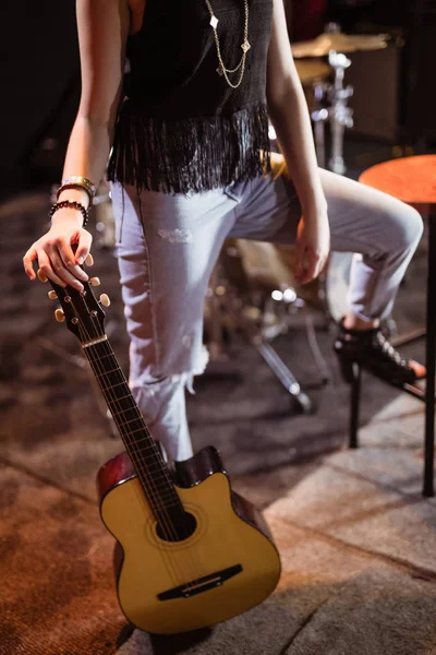 Vrouw met gitaar bij nightclub — Stockfoto