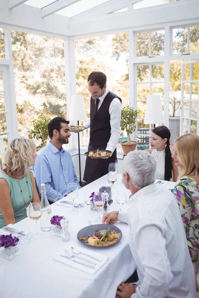 Camarero sirviendo comida a los clientes — Foto de Stock