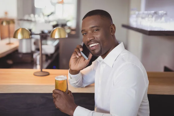 Hombre hablando por teléfono mientras toma cerveza — Foto de Stock