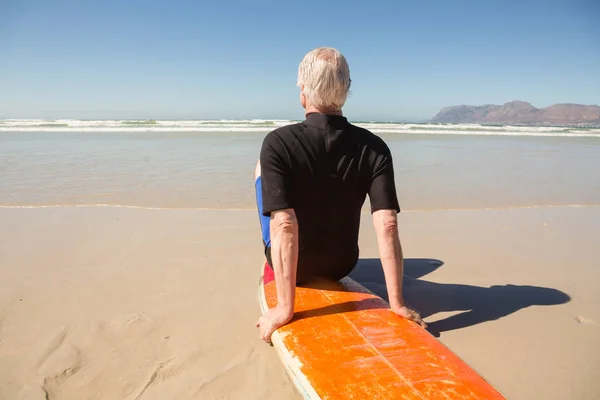 Senior man zit op de surfplank — Stockfoto