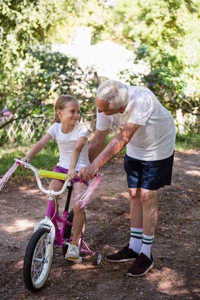 Nonno insegnare nipote come andare in bicicletta — Foto Stock